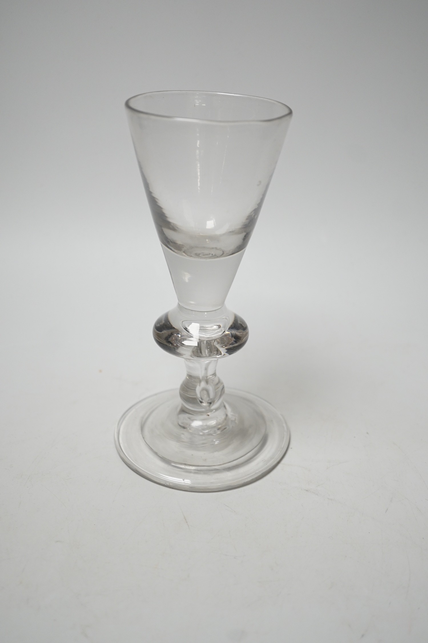 A George I heavy baluster wine glass, round funnel bowl above angular knop with air-tear, circa 1715-20, 18cm
